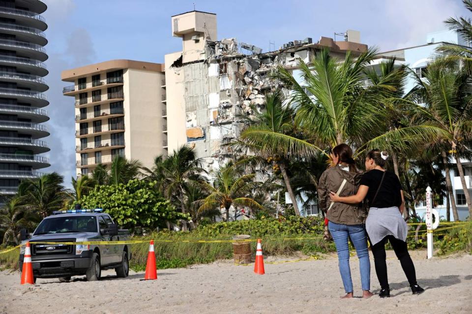 Maria Fernanda Martinez, left, and Mariana Cordeiro comfort each other while looking at the rubble of the Champlain Towers South in Surfside, Florida, Friday, June 25, 2021. The apartment building partially collapsed on Thursday, June 24.