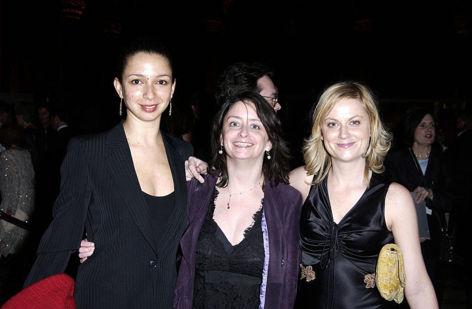 Maya is wearing a suit jacket, Amy is wearing a shiny top, and Rachel is wearing a simple top with a fashionable jacket over it