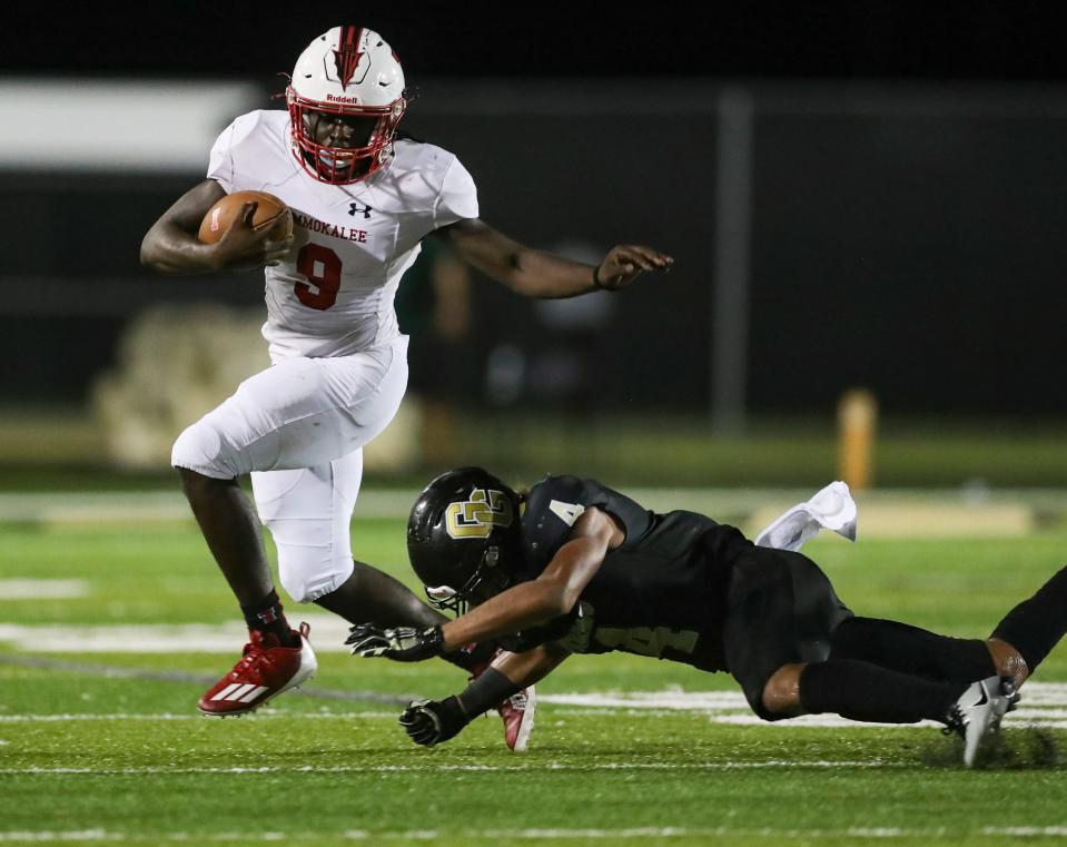 Immokalee Indians running back Justin Compere (9) dodges Golden Gate Titans safety Daniel Lopez (4) during the third quarter of a game at Golden Gate High School in Naples on Friday, Sept. 1, 2023.