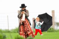 One of the twin boys seemed to be having fun playing with an umbrella, while mum Elsa was busy on her phone.