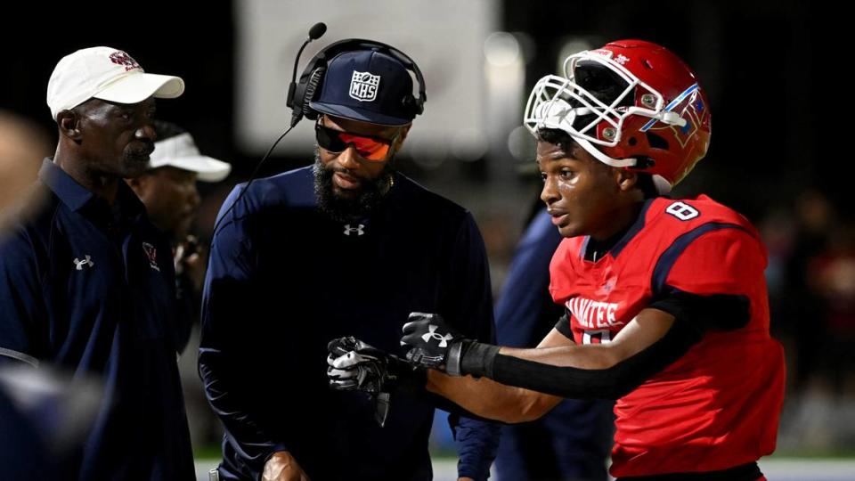 Manatee’s Raheim Sexil talks with coaches on the sidelines at Joe Kinnan Field at Hawkins Stadium on Friday, Nov. 17, 2023.