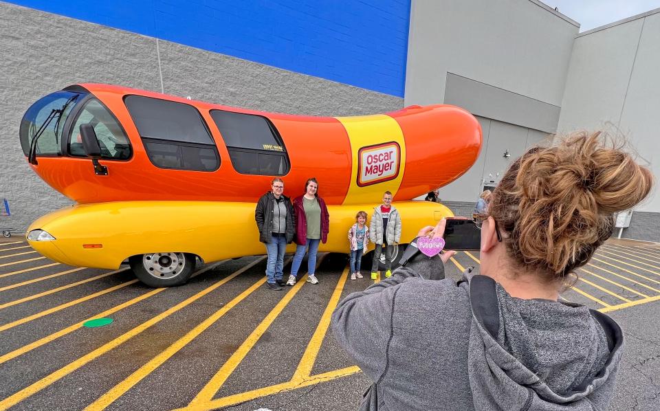 Amy Leavings takes photos of children Emma, Kelly, Audrey and Kenneth with the Oscar Mayer Wienermobile on Thursday outside of the Walmart in Ontario.