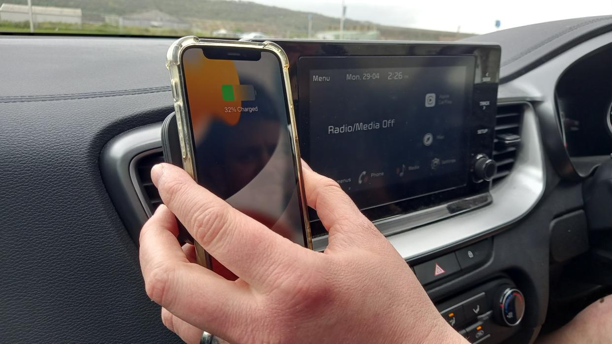  Hand attaching ESR Qi2 15W MagSafe Car Charger attached to car dashboard. 