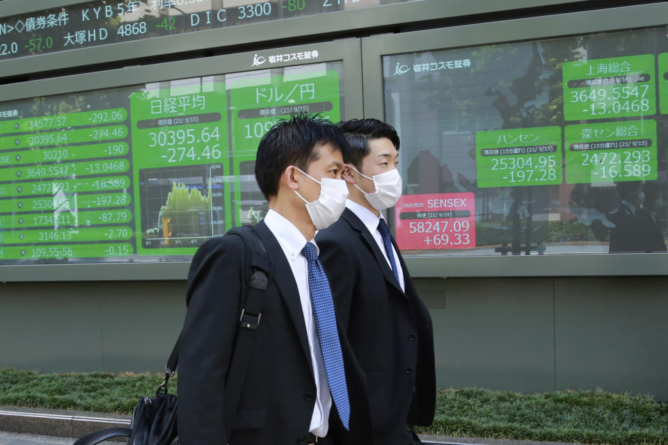 People walk by an electronic stock board of a securities firm in Tokyo, Wednesday, Sept. 15, 2021. Asian stock markets followed Wall Street down on Wednesday after U.S. inflation was lower than expected amid unease about the impact of the spread of the coronavirus's delta variant. (AP Photo/Koji Sasahara)