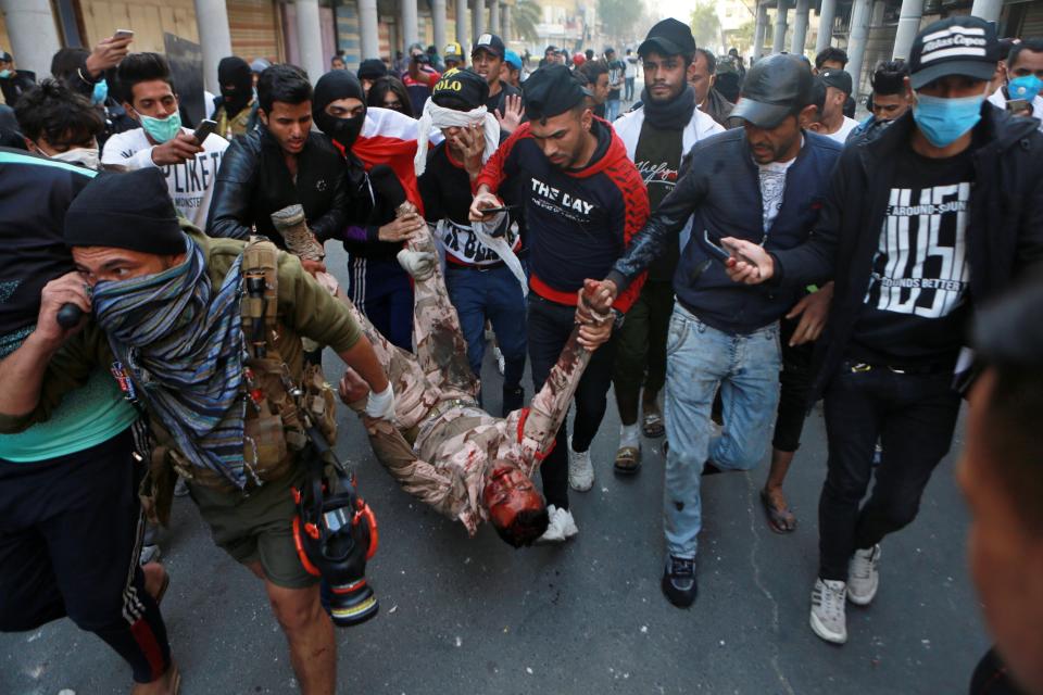 A soldier badly wounded during clashes with anti-government protesters is carried by demonstrators to a hospital during the ongoing protests in Rasheed Street, Baghdad, Iraq, Tuesday, Nov. 26, 2019. (AP Photo/Khalid Mohammed)