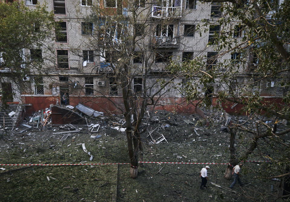 Local residents walk past a damaged building after a rocket attack early Wednesday morning, in Kramatorsk, eastern Ukraine, Wednesday, Aug. 31, 2022. (AP Photo/Kostiantyn Liberov)