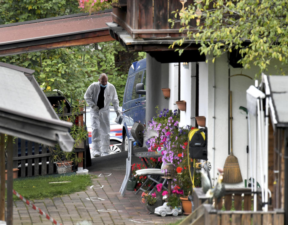 An investigator is seen at a crime scene in Kitzbuehl, Austria, Sunday, Oct. 6, 2019. Austrian police say a 25-year-old man's in custody after allegedly killing his ex-girlfriend, her family, and her new boyfriend in the Alpine resort town of Kitzbuehel. The 25-year-old turned himself to police in the town east of Innsbruck and admitted to the five slayings early Sunday morning, Austrian news agency APA reported. (AP Photo/Kerstin Joensson)