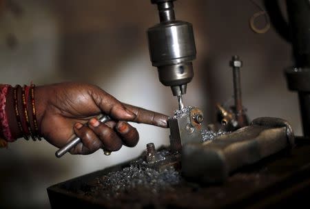 A worker makes auto parts on a machine inside a workshop in Faridabad, December 24, 2015. REUTERS/Adnan Abidi/Files