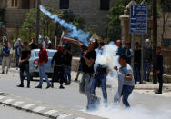 A Palestinian protester hurls back a tear gas canister fired by Israeli troops during clashes following a protest in solidarity with Palestinian prisoners held by Israel, in the West Bank town of Bethlehem April 17, 2017. REUTERS/Ammar Awad