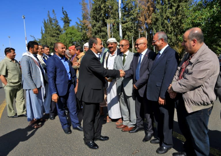 Members of the Huthi delegation (L) returning from peace talks in Sweden shake hands with supporters upon their arrival at Sanaa International Airport in Yemen's capital on December 14, 2019