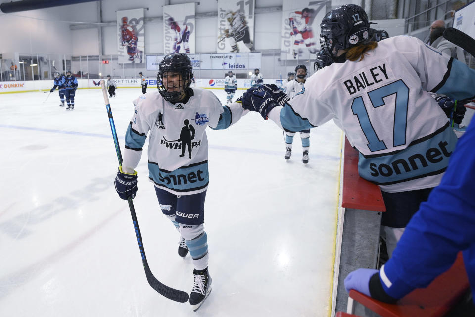 Team Sonnet defender Jacquie Greco, left, celebrates her goal with Katherine Bailey (17) during the second period of the team's hockey game against Team Bauer as part of the Secret Dream Gap Tour, Friday, March 4, 2022, in Arlington, Va. Team Sonnet won 4-3. The growth of girls and women's hockey in the Washington area is still a work in progress almost two decades into a boom of youth participation in the sport credited to Alex Ovechkin and the NHL's Capitals.(AP Photo/Nick Wass)