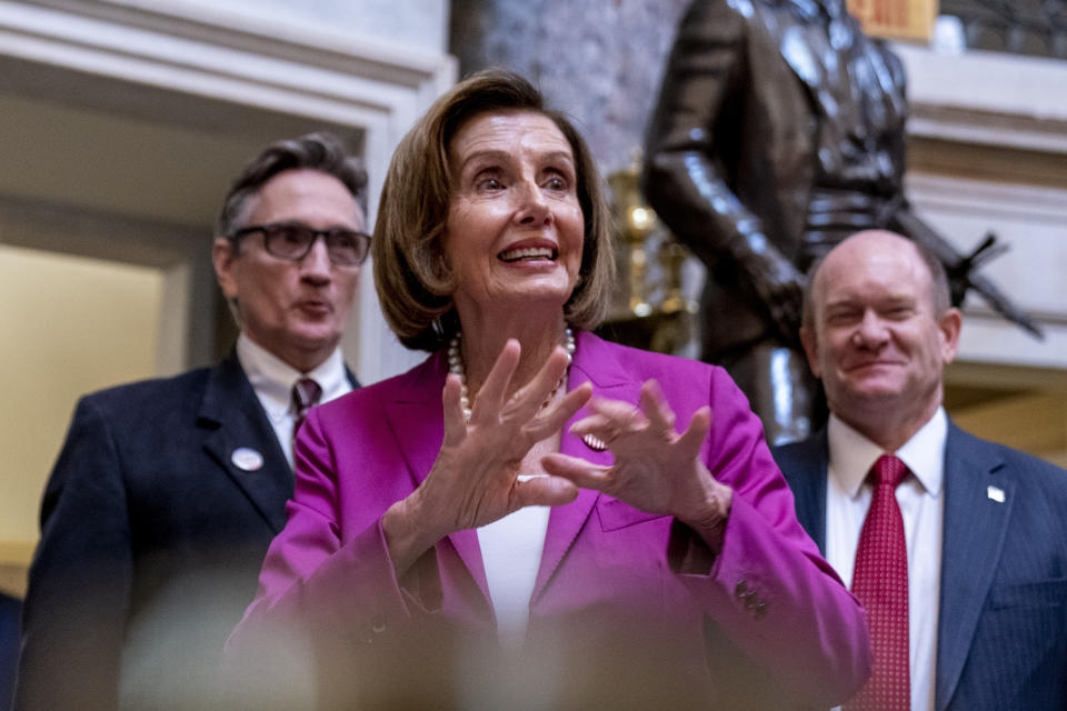 House Speaker Nancy Pelosi of Calif., center, and Sen. Chris Coons, D-Del., right, walk former President Harry S. Truman's eldest grandson Clifton Truman Daniel, left, through Statuary Hall after a ceremony to unveil the Congressional statue of the former president in the Rotunda of the U.S. Capitol Building in Washington, Thursday, Sept. 29, 2022. (AP Photo/Andrew Harnik)