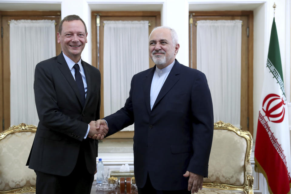 Iranian Foreign Minister Mohammad Javad Zarif, right, shakes hand with French presidential envoy Emmanuel Bonne, as they pose for photos, in Tehran, Iran, Wednesday, July 10, 2019. France sent Bonne to Tehran to urge Iran to return to complying with the terms of the deal "without delay." (AP Photo/Ebrahim Noroozi)