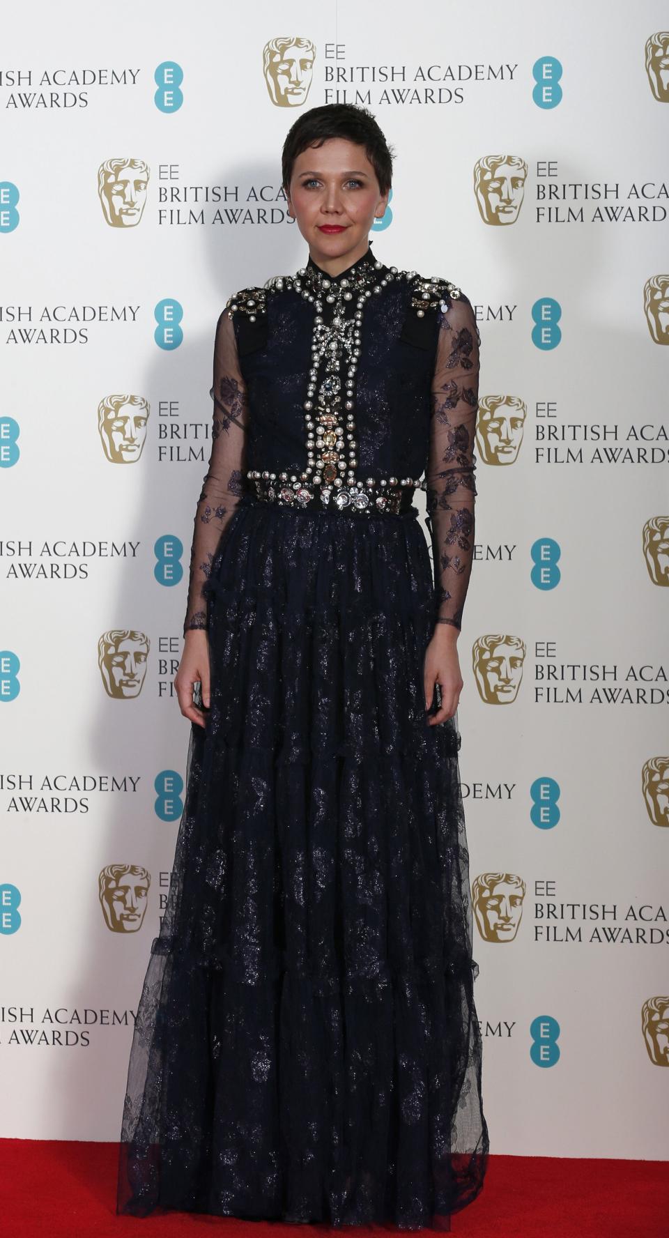 Actress Maggie Gyllenhaal poses for a photograph at the British Academy of Film and Arts (BAFTA) awards ceremony at the Royal Opera House in London February 16, 2014. REUTERS/Suzanne Plunkett (BRITAIN - Tags: ENTERTAINMENT)