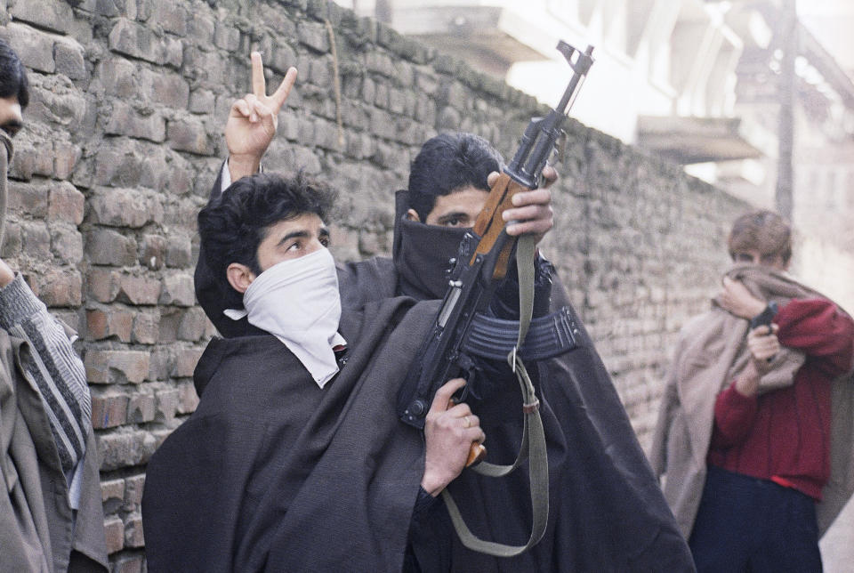 FILE - Young Muslim separatists come into the streets with guns, defying an army curfew and demanding independence in Kashmir, Monday, Jan. 23, 1990. Kashmir is divided between India and Pakistan and claimed by both in its entirety. The region’s fury at Indian rule has been long seething and most Muslim Kashmiris support the rebel goal of uniting the territory, either under Pakistani rule or as an independent country. An armed rebellion against Indian rule began in 1990's. (AP Photo/Ajit Kumar, File)