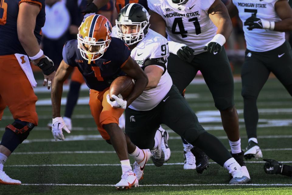 Michigan State defensive tackle Maverick Hansen (97) tackles Illinois wide receiver Isaiah Williams (1) during the first half of an NCAA college football game, Saturday, Nov. 5, 2022, in Champaign, Ill.