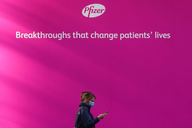 A person walks past the Pfizer Headquarters building