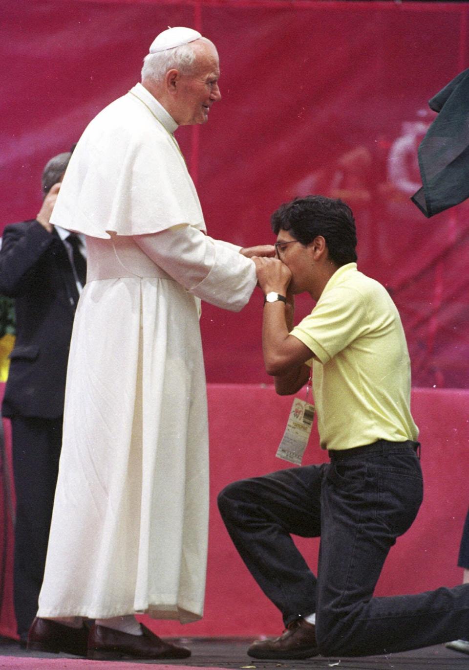 FILE - A World Youth Day participant kisses the ring of Pope John Paul II at Mile High Stadium in Denver on Aug. 12, 1993. (AP Photo/Jeff Robbins, File)
