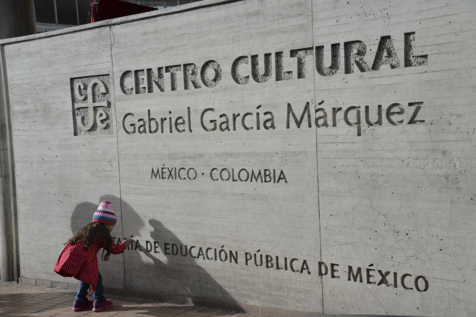 Una niña toca el letrero fuera del centro cultural Gabriel García Márquez en el centro de Bogotá, Colombia, el jueves 17 de abril de 2014. García Márquez murió en su casa en la Ciudad de México el jueves. El fallecimiento del autor de “Cien años de soledad” sumió en el dolor a millones de lectores que conocieron Latinoamérica gracias a su obra. (Foto AP/Diana Sanchez)