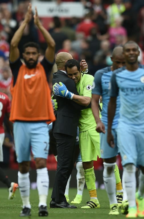 Manchester City's manager Pep Guardiola embraces goalkeeper Claudio Bravo as they celebrate after defeating Manchester United in their English Premier League match, at Old Trafford, on September 10, 2016