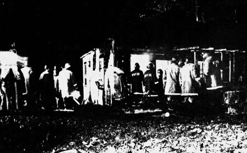 Warren volunteer firemen examine the charred outside of a cottage where Jerry Krosan, 68, died in a fire on Saturday, Nov. 10, 1973.