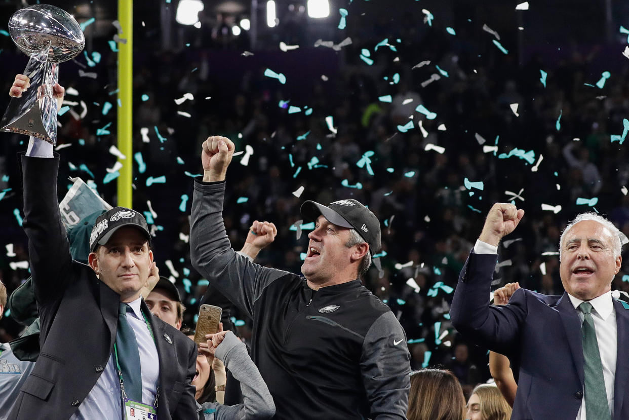 FILE - In this Feb. 4, 2018, file photo, Philadelphia Eagles general manager Howie Roseman, left, holds up the Vince Lombardi Trophy as he celebrates with head coach Doug Pederson, center, and owner Jeffrey Lurie after the NFL Super Bowl 52 football game against the New England Patriots, in Minneapolis. Owning the last pick in the first round of the NFL draft is a spot the Philadelphia Eagles want more often because it goes to the Super Bowl champions. Roseman is known for making moves. He's one of the most aggressive executives in the league. It's an organizational philosophy that's also reflected by coach Doug Pederson's playcalling.  "From our perspective, we're going to keep swinging," Roseman said. "That starts with (owner) Jeffrey (Lurie). (AP Photo/Matt Slocum, File)