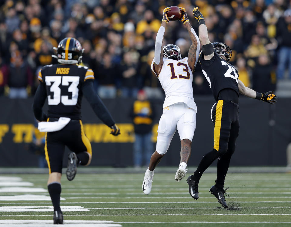 Minnesota wide receiver Rashod Bateman, center, pulls down a reception over Iowa defensive back Jack Koerner, right, during the first half of an NCAA college football game, Saturday, Nov. 16, 2019, in Iowa City, Iowa. (AP Photo/Matthew Putney)