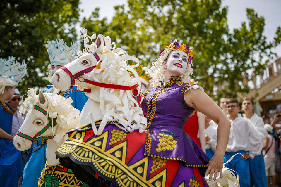 People take part of the "Fete des Vignerons" (winegrowers' festival in French), parade during the official opening parade prior to the first representation and crowning ceremony in Vevey, Switzerland, Thursday, July 18, 2019. Organized in Vevey by the brotherhood of winegrowers since 1979, the event will celebrate winemaking from July 18 to August 11 this year. (Valentin Flauraud/Keystone via AP)