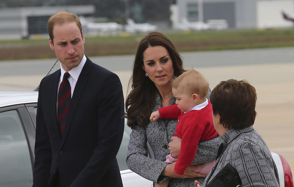 Britain's Prince William and Kate the Duchess of Cambridge holding Prince George walk along the tarmac with Lady Cosgrove before they board their flight in Canberra, Australia, Friday, April 25, 2014. The Duke and Duchess concluded their three week state visit by attending the Anzac Day dawn service and parade, laying a wreath and planting a Lone Pine tree before departing for London with son Prince George.(AP Photo/Rob Griffith)