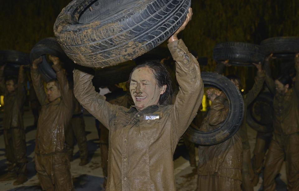 A trainee holds up a tyre during the Tianjiao Special Guard/Security Consultant Ltd. bodyguard training camp in Beijing