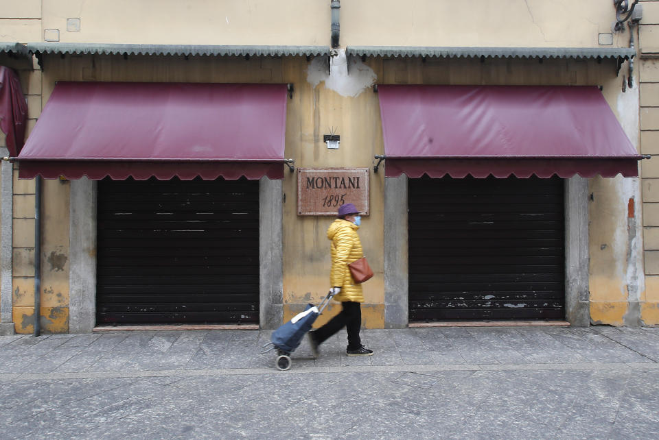 A woman walks in Codogno, Italy, Thursday, March 12, 2020. The northern Italian town that recorded Italy’s first coronavirus infection has offered a virtuous example to fellow Italians, now facing an unprecedented nationwide lockdown, that by staying home, trends can reverse. Infections of the new virus have not stopped in Codogno, which still has registered the most of any of the 10 Lombardy towns Italy’s original red zone, but they have slowed. For most people, the new coronavirus causes only mild or moderate symptoms. For some it can cause more severe illness. (AP Photo/Antonio Calanni)