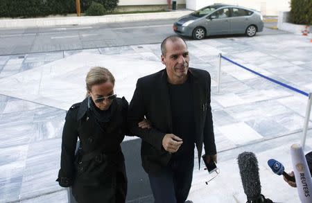 Greek Finance Minister Yanis Varoufakis (R) arrives at the parliament building with his wife Danae Stratou ahead of a cabinet meeting in Athens, February 21, 2015. REUTERS/Kostas Tsironis