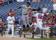 Washington Nationals Juan Soto (22) is safe at first as Pittsburgh Pirates second baseman Erik Gonzalez (2) reaches for the tag during the first inning of a baseball game, Monday, June 14, 2021, in Washington. The call on the field was out but was overturned after a review. (AP Photo/Carolyn Kaster)