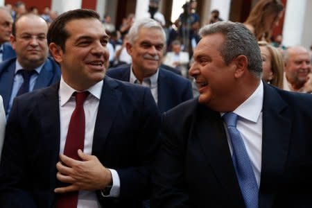 FILE PHOTO: Greek Prime Minister Alexis Tsipras, seen wearing a tie, jokes with Greek Defense Minister Panos Kammenos before his speech at the parliamentary group of Syriza and Independent Greeks in Athens, Greece, June 22, 2018. REUTERS/Costas Baltas