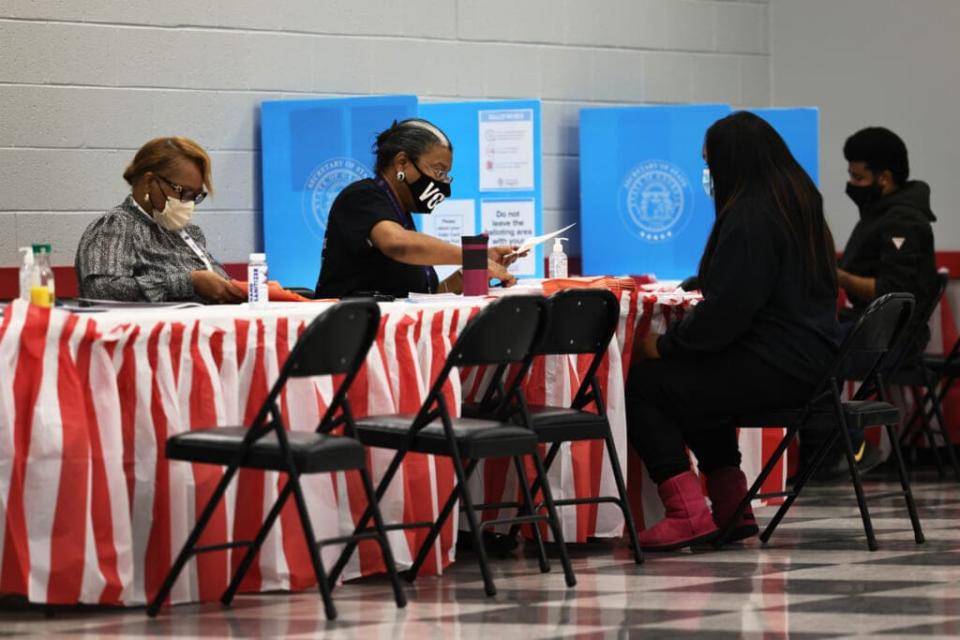 People check in as they prepare to cast their vote in the Georgia run-off election at C.T. Martin Natatorium and Recreation Center on January 05, 2021 in Atlanta, Georgia. (Photo by Michael M. Santiago/Getty Images)