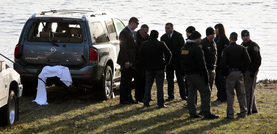 Law enforcement work beside Silver Lake near an SUV that was found in the water with a baby inside in Highland, Ill., on Thursday, March 16, 2017. The infant is being treated at a St. Louis hospital after the car the child was in rolled into the lake. (Robert Cohen/St. Louis Post-Dispatch via AP)