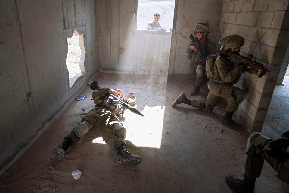 An Israeli soldier pretending to be dead Palestinian militant lies on the ground during a training session simulating urban warfare at the Zeelim army base, southern Israel, Jan. 4, 2022.