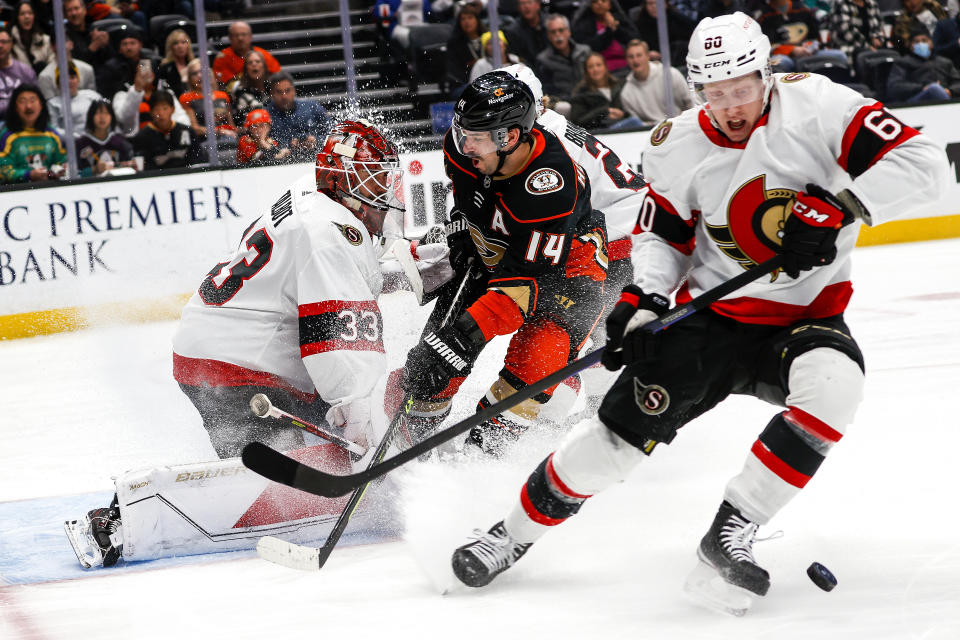 Ottawa Senators defenseman Lassi Thomson, right, clears the puck with goalie Cam Talbot, left, defending against Anaheim Ducks forward Adam Henrique during the first period of an NHL hockey game Friday, Nov. 25, 2022, in Anaheim, Calif. (AP Photo/Ringo H.W. Chiu)