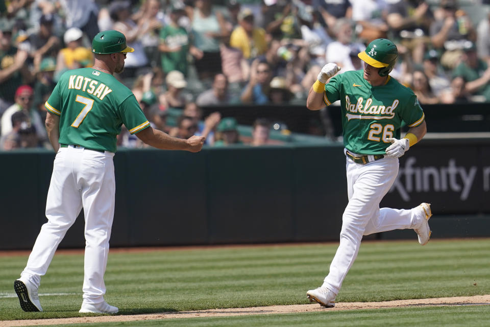 Oakland Athletics' Matt Chapman, right, is congratulated by third base coach Mark Kotsay after hitting a home run against the New York Yankees during the fourth inning of a baseball game in Oakland, Calif., Saturday, Aug. 28, 2021. (AP Photo/Jeff Chiu)