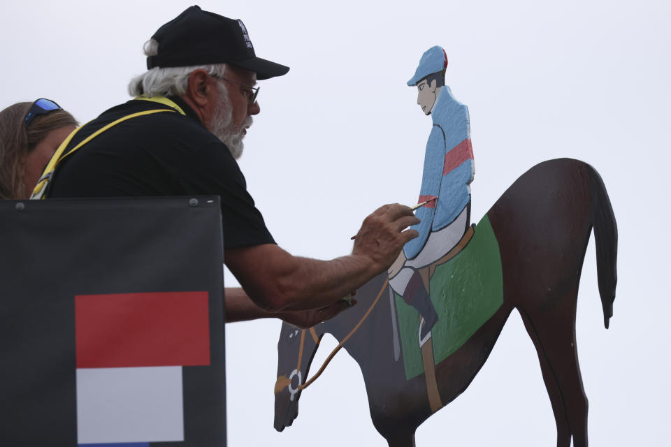 Artist Dick Hageman paints a weathervane in the colors of National Treasure, with jockey John Velazquez after winning the148th running of the Preakness Stakes horse race at Pimlico Race Course, Saturday, May 20, 2023, in Baltimore. (AP Photo/Julia Nikhinson)