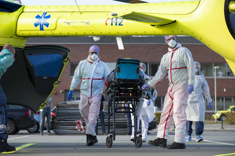 A COVID-19 patient is being carried into a helicopter at Flevoziekenhuis, or FlevoHospital, in Almere, Netherlands, Friday, Oct. 23, 2020. In the latest sign of the scale of the coronavirus pandemic sweeping across Europe, a helicopter is scheduled to start airlifting COVID-19 patients from the Netherlands to an intensive care unit in the German city of Muenster.(AP Photo/Peter Dejong)