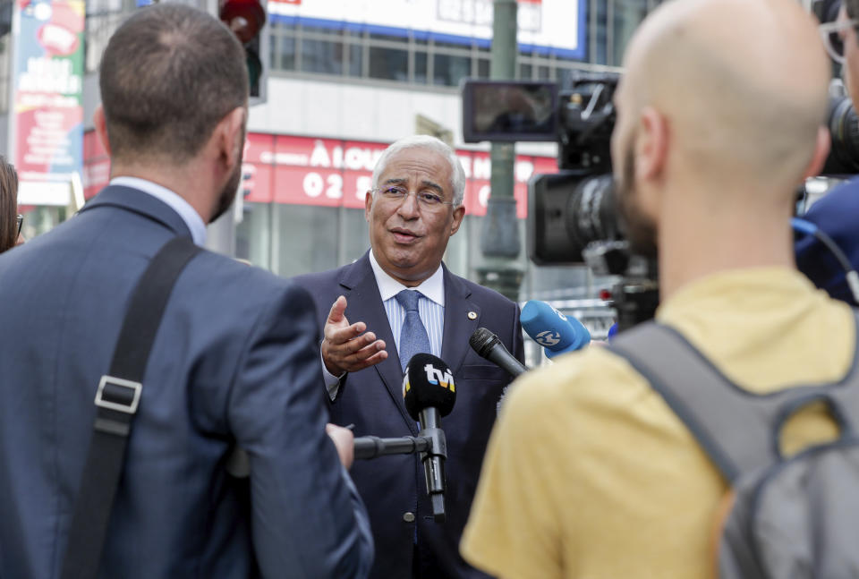 Portugal's Prime Minister Antonio Costa, center, speaks with journalists in the European Quarter outside of an EU summit in Brussels, Sunday, July 19, 2020. Leaders from 27 European Union nations meet face-to-face for a third day to assess an overall budget and recovery package spread over seven years estimated at some 1.75 trillion to 1.85 trillion euros. (Stephanie Lecocq, Pool Photo via AP)