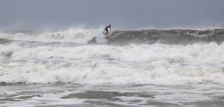 Surfer Ben Powell of Ocean Isle Beach rides a large wave during the effects of Hurricane Arthur, in Ocean Isle Beach, North Carolina July 3, 2014. REUTERS/Randall Hill