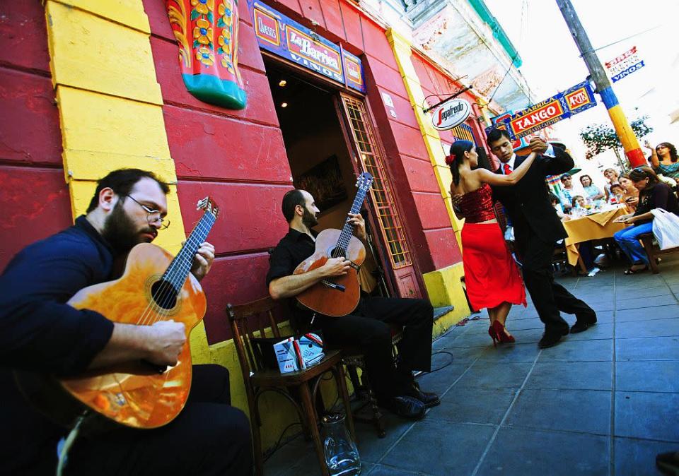 A couple dances the traditional dance Tango in front of a restaurant in La Boca district in Buenos Aires, Argentina.