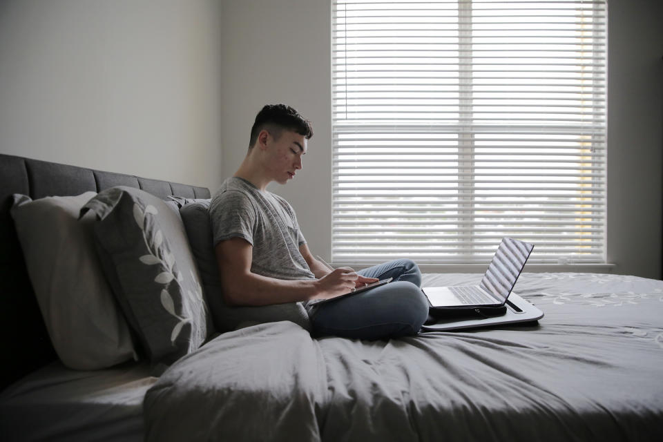 JACKSONVILLE, FL-November 12, 2020: Eric Lipka takes notes during their online psychology class in the bedroom of their Jacksonville, Florida apartment. Georgetown University sophomore Eric Lipka, 19, started college on campus but the outbreak of COVID-19 forced Lipka into a remote learning situation from their apartment in Jacksonville, FL. Lipka is currently waiting for the school to announce its plans for the spring semester which will determine if they return to in-person class or take a gap semester. (Photo by Bob Self for The Washington Post via Getty Images)