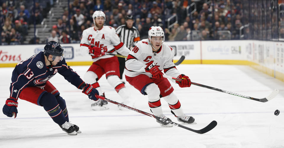 Carolina Hurricanes' Teuvo Teravainen, right, of Finland, carries the puck across the blue line as Columbus Blue Jackets' Cam Atkinson defends during the first period of an NHL hockey game Thursday, Jan. 16, 2020, in Columbus, Ohio. (AP Photo/Jay LaPrete)