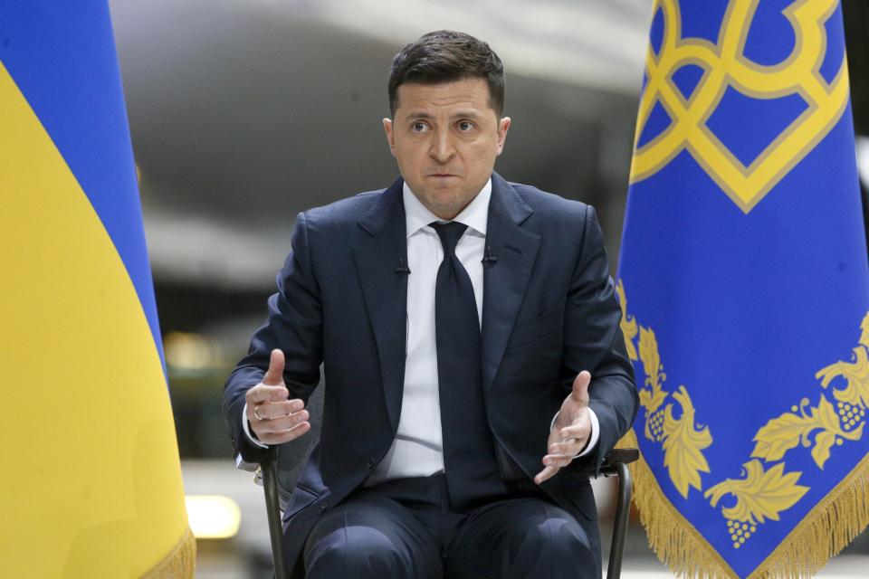 Ukrainian President Volodymyr Zelenskyy gestures while speaking to the media during a news conference with the world's largest airplane, Ukrainian Antonov An-225 Mriya in the background at the Antonov aircraft factory in Kyiv, Ukraine, Thursday, May 20, 2021. (AP Photo/Efrem Lukatsky)