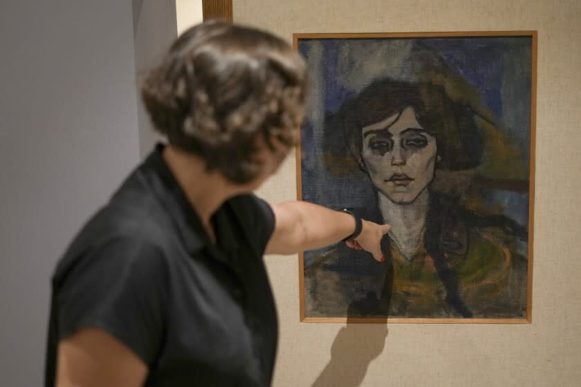 Inna Berkowits, an art historian at the Haifa University's Hecht Museum explains about Amadeo Modigliani's painting "Maud Abrantes" that is painted on the reverse side of a canvas with another painting by him titled, "Nude with a Hat," and is on display at Haifa University's Hecht Museum in Haifa, Israel, June 28, 2022. Curators at the museum using x-ray technology have discovered three previously unknown sketches by the celebrated 20th century artist hiding beneath the surface of the painting. (AP Photo/Ariel Schalit)