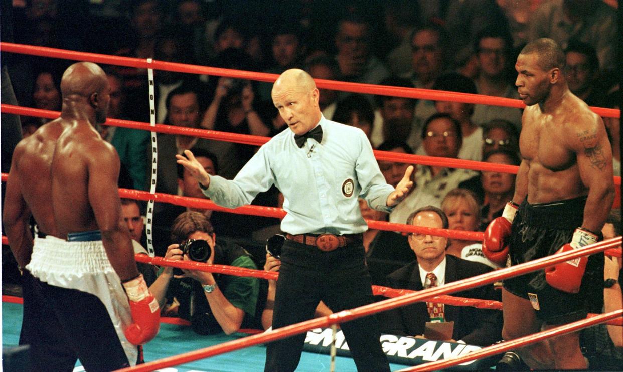 Referee Mills Lane (C) steps between World Boxing Association heavyweight champion Evander Holyfield (L) and challenger Mike Tyson (R) during the third round of their fight in the MGM Grand Garden Arena 28 June. Holyfield won by disqualification after Tyson bit his ears.  AFP PHOTO/MIKE NELSON  (Photo credit should read MIKE NELSON/AFP via Getty Images)