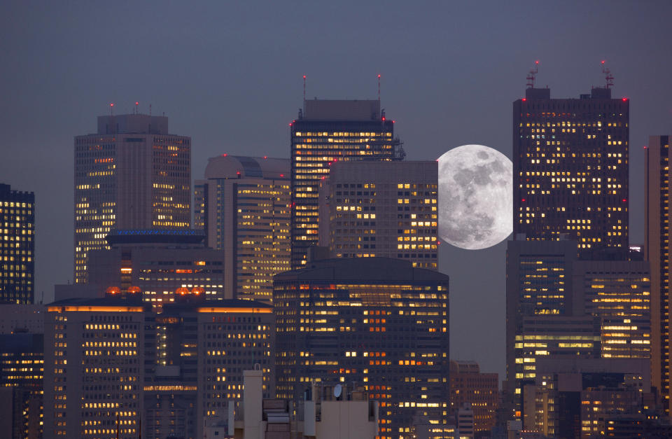 Der Mond ist zwischen Gebäuden des Shinjuku Business District in Tokio zu sehen.  